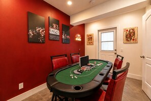 A room with a green felt blackjack table, red chairs, and poker-themed artwork on the walls. - 3BR Guitar House + Poker Lounge Near Hard Rock (Hollywood)