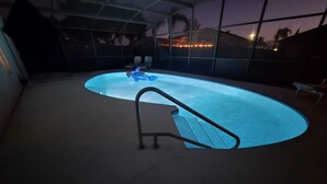 Ein beheiztes Hallenbad mit einer Leiter, umgeben von einer Glaskuppel.