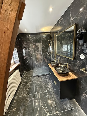 A modern bathroom with black marble walls, a wooden vanity, and a large mirror. - Domaine du Patineau (Chevillon-sur-Huillard)