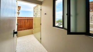 Ein Zimmer mit Dusche, Fenster und Blick nach draußen.