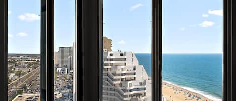 A corner room with a view of a beach and a parking lot.