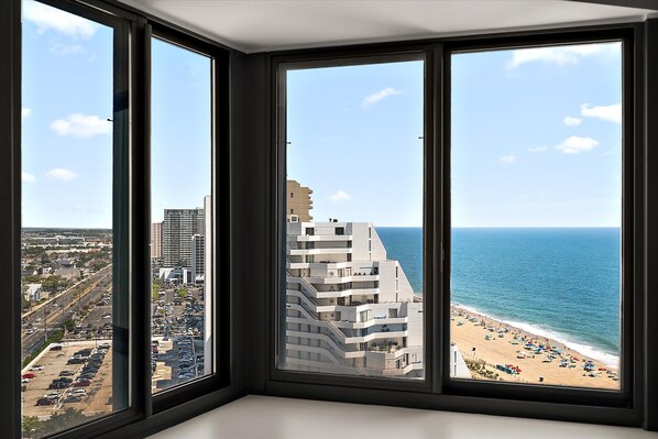 A corner room with a view of a beach and a parking lot.