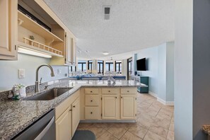 A modern kitchen with granite countertops, a double sink, and a central island.