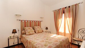 A bedroom with a bed, two bedside tables with lamps, a chair, and curtains. - GRENIER - PERPIGNAN - Gîte (PERPIGNAN)