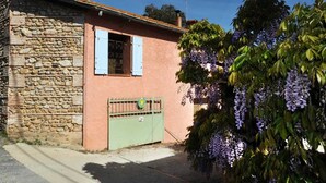 A stone building with a pink facade and a green gate. - GRENIER - PERPIGNAN - Gîte (PERPIGNAN)