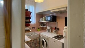 A compact kitchen with a washing machine, microwave, and a small sink. - Le coscollet 1 - ILLE-SUR-TET (ILLE-SUR-TET)