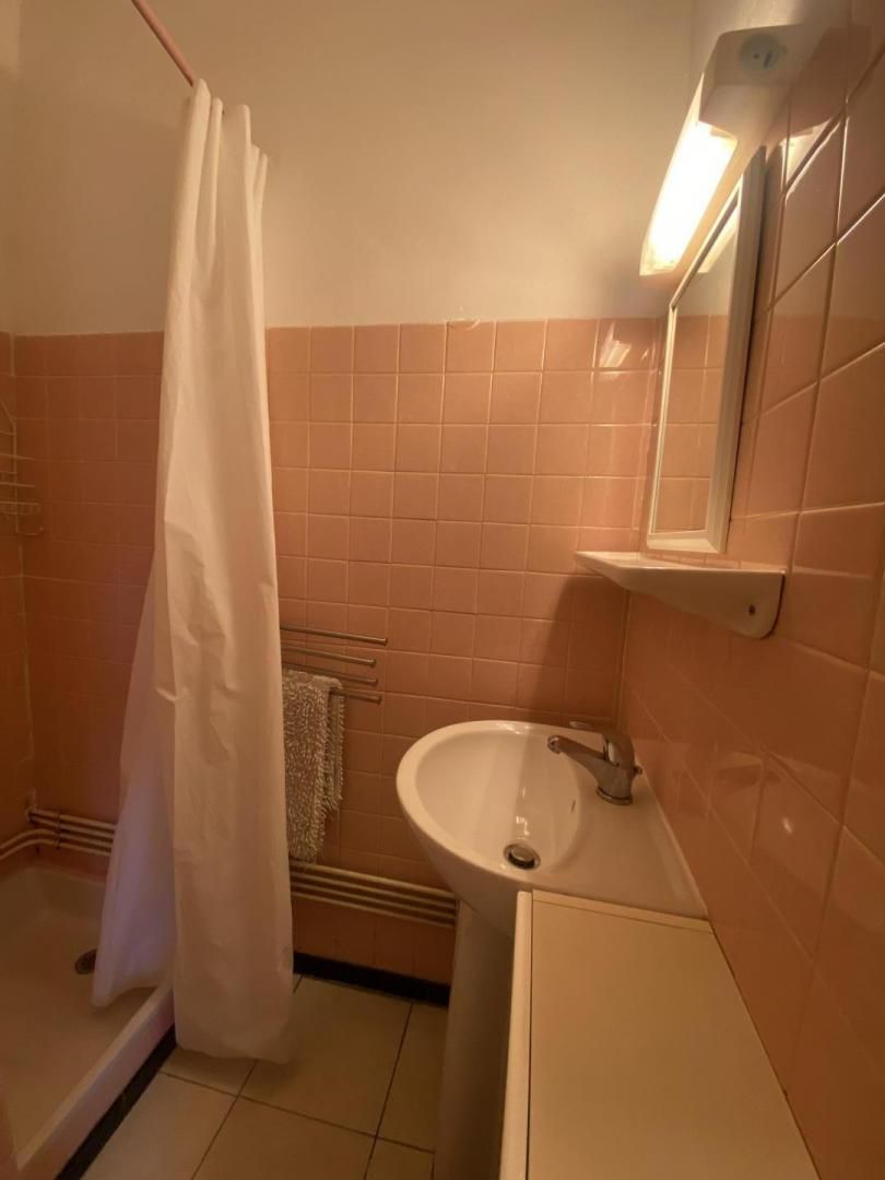 A bathroom with a white sink, a mirror, and a shower curtain.
