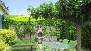 A patio with a table and chairs, a barbecue grill, and a green umbrella. - Le coscollet 1 - ILLE-SUR-TET (ILLE-SUR-TET)