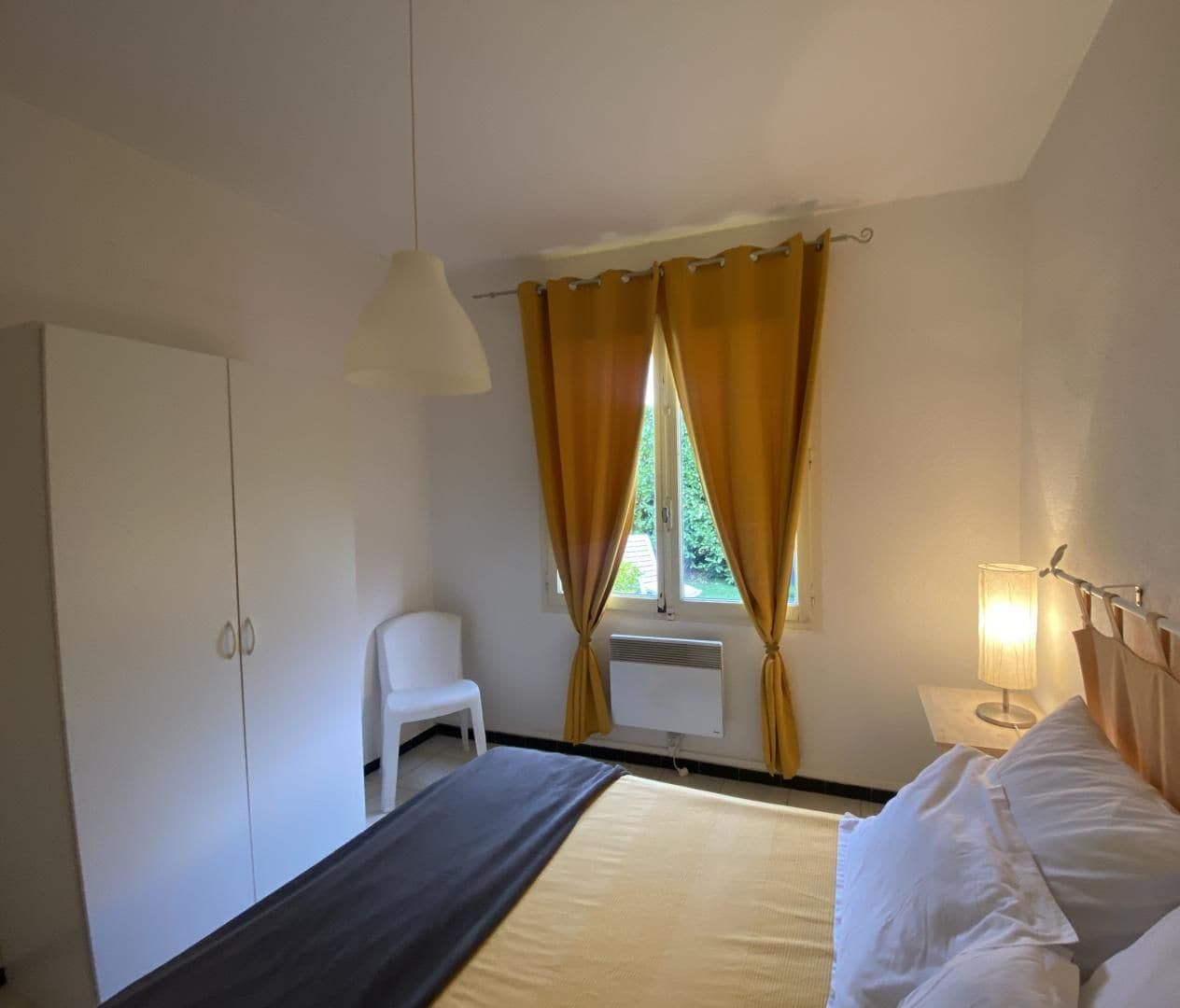 A bedroom with a bed, a desk, a chair, and a wardrobe.