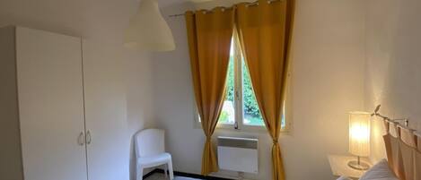 A bedroom with a bed, a desk, a chair, and a wardrobe.