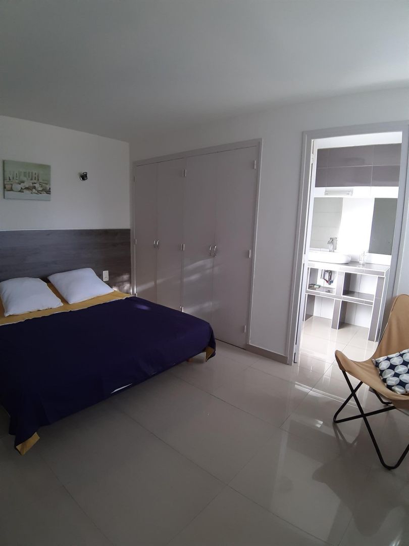 Une chambre à coucher avec un lit, une armoire et une chaise.