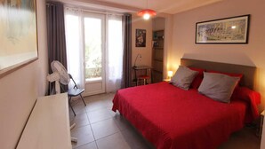 A bedroom with a bed, a desk, a chair, a fan, a lamp, and a window with curtains. - L'arbousier - SAINT CYPRIEN (SAINT CYPRIEN)
