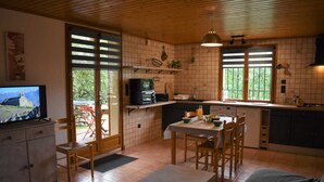 Una cocina acogedora con comedor, televisor y vistas al exterior.