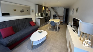 A modern living room with a sofa, coffee table, and dining area.
