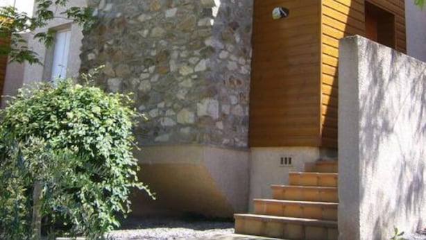 A modern building with a stone facade and wooden upper levels.