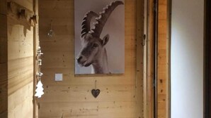 Un intérieur en bois orné d’une tête d’animal fixée au mur, d’un petit tabouret et d’une décoration en forme de cœur.