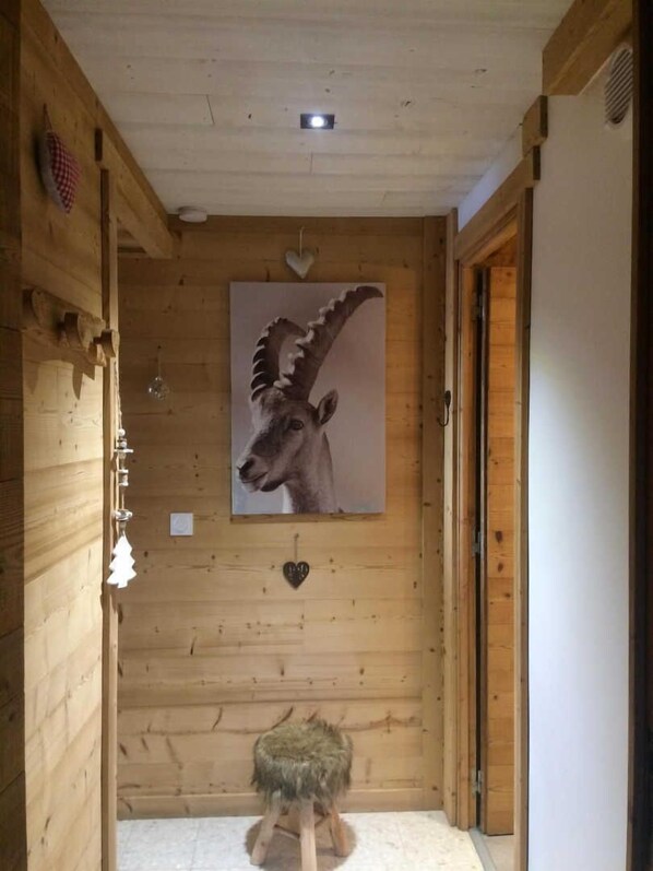 A wooden interior with a mounted animal head, a small stool, and a heart-shaped decoration on the wall. - La close - BOLQUERE-PYRENEES 2000 (BOLQUERE-PYRENEES 2000)