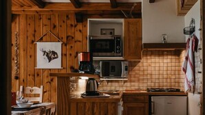 Une cuisine rustique avec des meubles en bois, un îlot central et un four à micro-ondes.