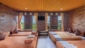 A room with two beds, a TV, and a view of greenery. - Jawa Dwipa Villa (Wonosobo)