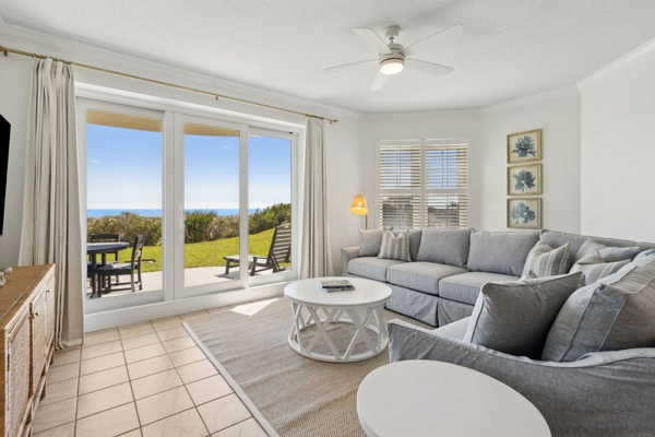 Gorgeous Living Room Featuring an Oversized Sectional, a Flat Screen TV, and Sliders that Lead to a Beautiful Patio with Stunning Oceanfront Views