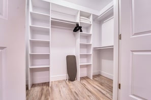 A walk-in closet with multiple shelves and a hanging rod.