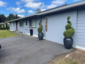 A building with a 'WELCOME' sign, potted topiary, and a clear sky. - Enjoyable 3-bedroom house in quaint Forks for your getaway. (Forks)
