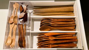 Un cajón con varios utensilios de madera, como cucharas, tenedores y palillos.