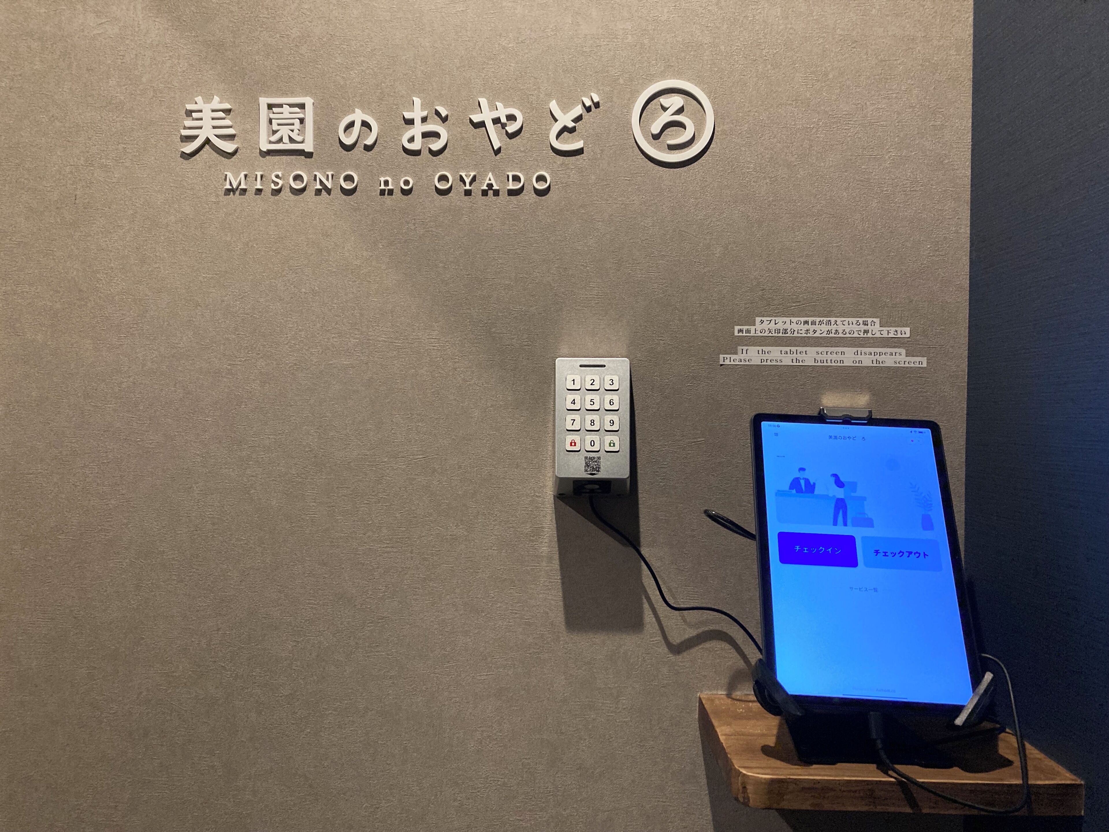 Un dispositivo fissato al muro, dotato di tastierino e schermo che mostra un'interfaccia utente.
