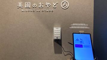 Un dispositivo fissato al muro, dotato di tastierino e schermo che mostra un'interfaccia utente.