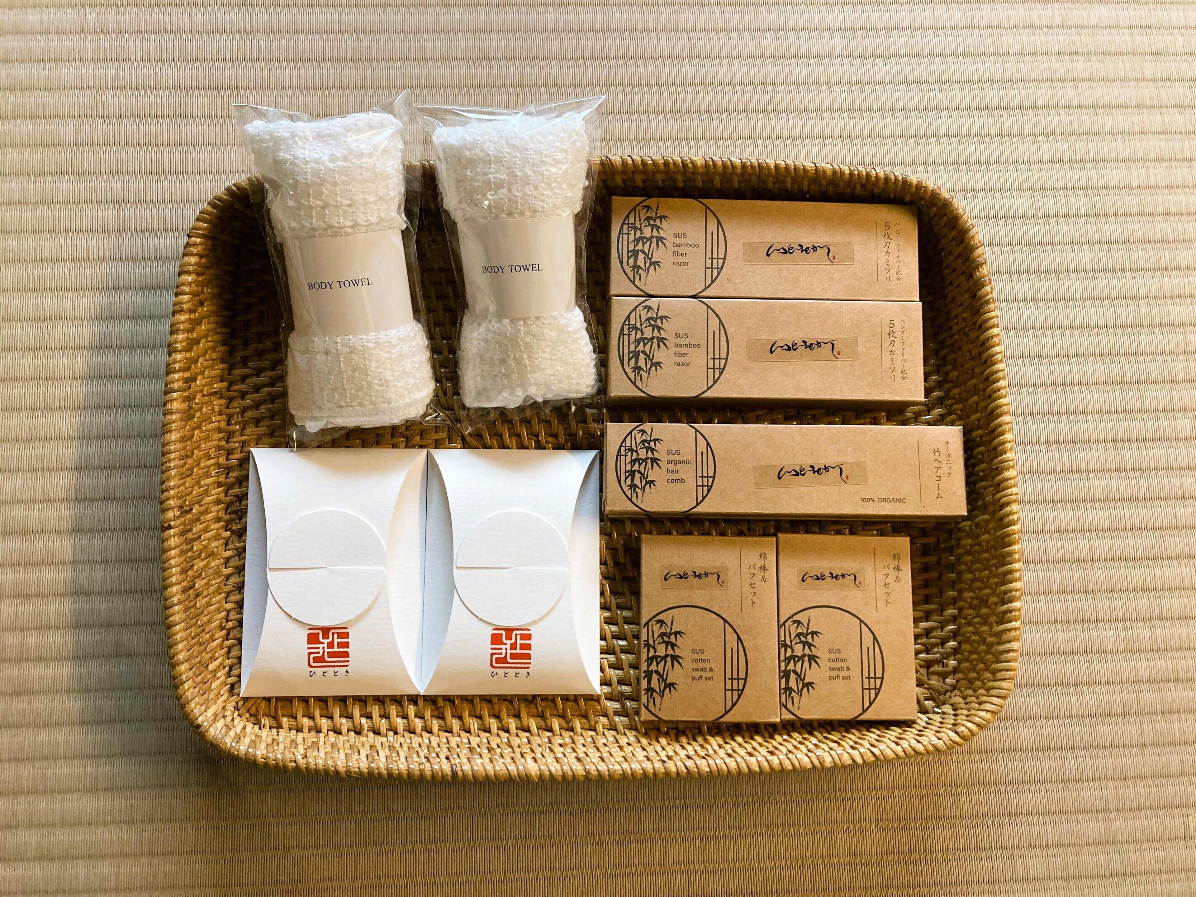 A wicker basket containing various personal care items including body towels, hair combs, and organic hair care products.