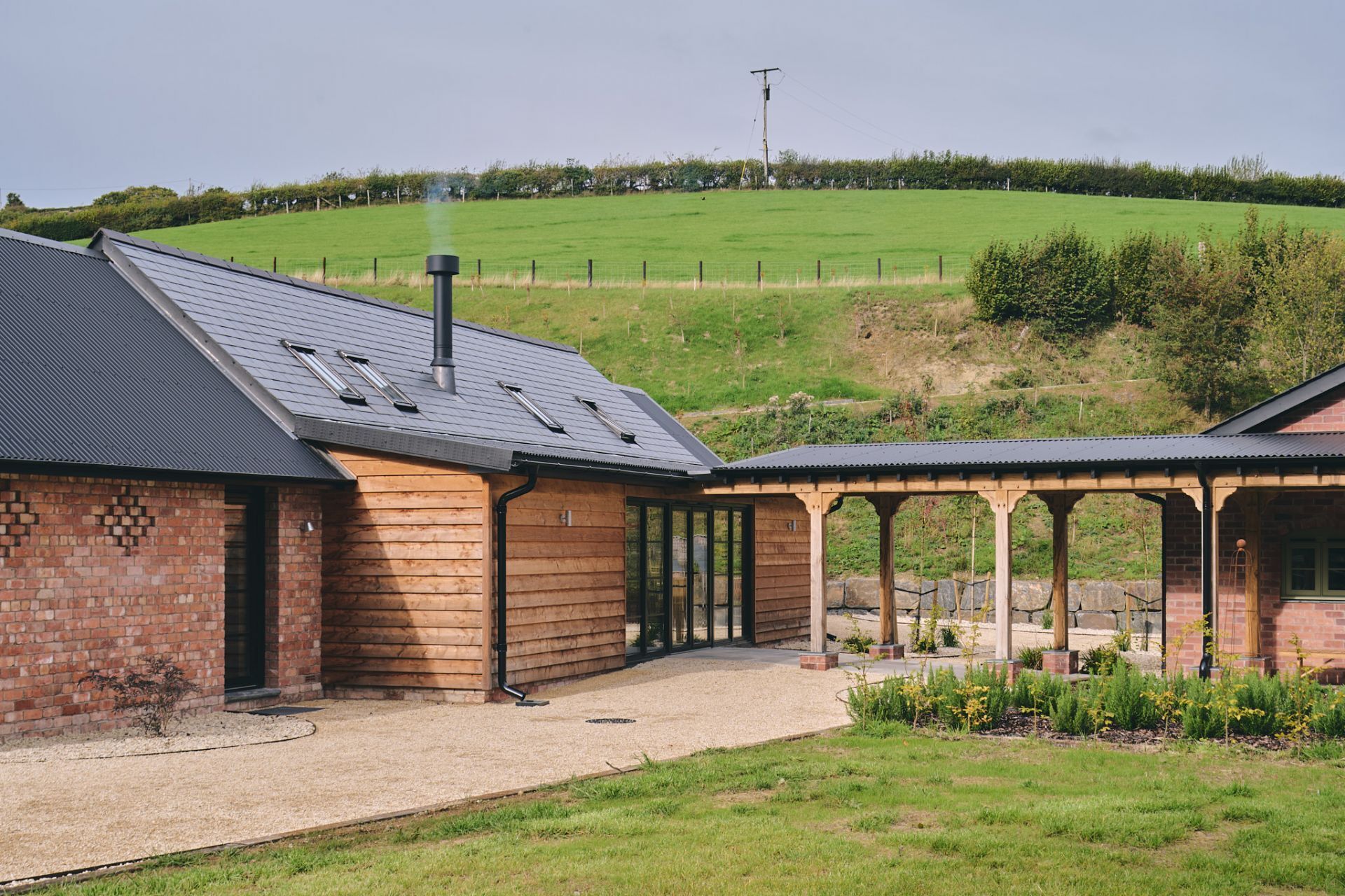 A brick building with a sloped roof and a covered outdoor area with a pergola.