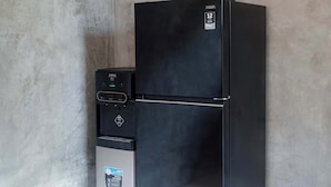 Un refrigerador negro con dispensador de agua y panel de control.
