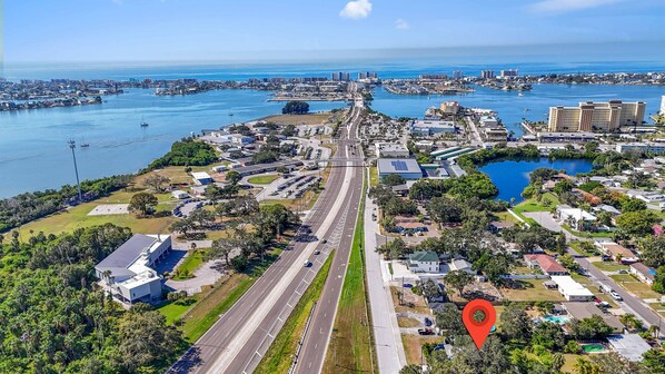 Vue aérienne d’une ville côtière, avec une autoroute bien visible, un port de plaisance et des quartiers résidentiels.