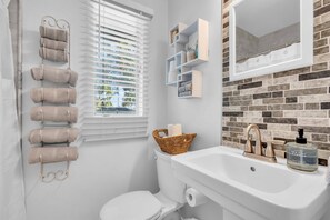 Une salle de bain équipée de toilettes, d’un lavabo et d’un porte-serviettes.