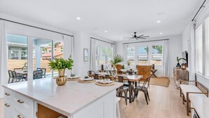 A spacious kitchen with a large island, dining area with chairs, and a view of the outdoors. - Vibe Out: Private beach steps away, Heated pool, Golfcart, Game room, Bunk rooms (Miramar Beach)
