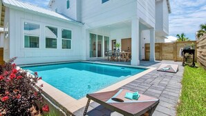 A two-story house with a swimming pool, outdoor seating area, and a fenced backyard. - Vibe Out: Private beach steps away, Heated pool, Golfcart, Game room, Bunk rooms (Miramar Beach)