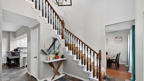 A staircase with white railings and wooden steps leading to a dining area. - Modern 5BR/2.5BA w/Private Pool  Sleeps 16 ppl (Allen)