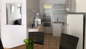 A compact kitchen with white cabinets, a coffee machine, and a refrigerator. - Apartment in Roses on the seafront.MONTEMAR (Roses)