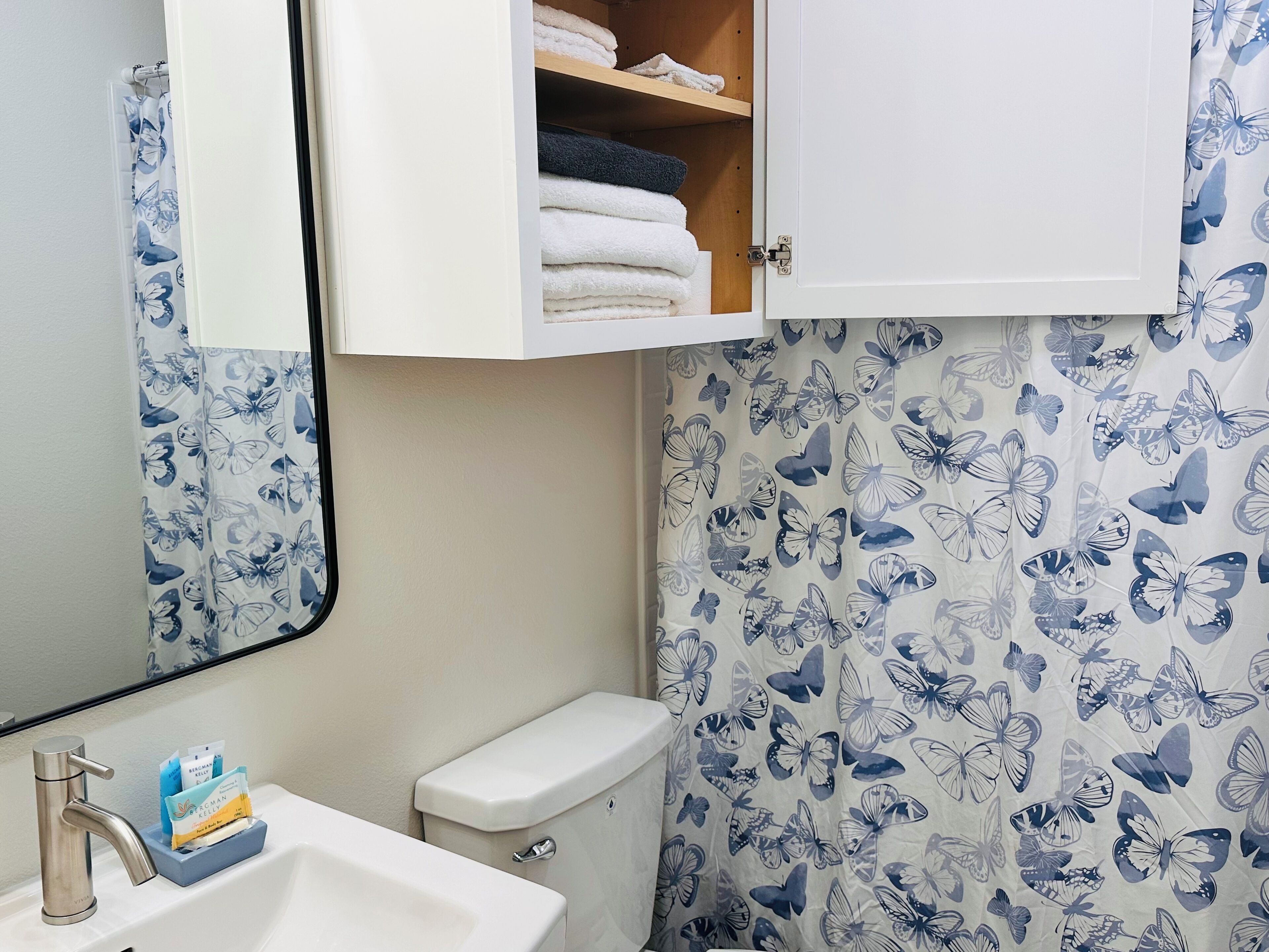 A bathroom with a toilet, sink, and a cabinet above the sink.