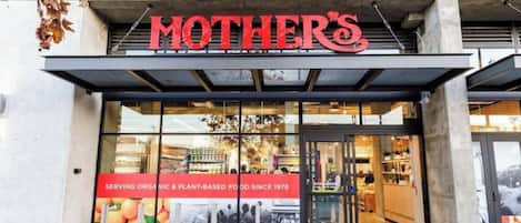 A storefront with a large sign reading 'MOTHER'S' and a banner stating 'SERVING ORGANIC & PLANT-BASED FOOD SINCE 1978'.