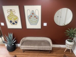 A room with a sofa, two framed artworks, a mirror, and potted plants. - Cozy and Spacious 5 bedrooms House at Duplex (Vernon)