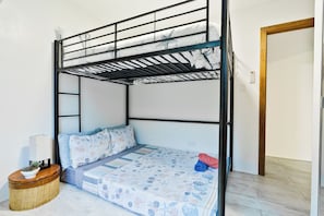 A bunk bed with a lower bunk, a bedside table with a lamp, and a small round rug. - Ocean and sunset views, bright eco design,  4-bedroom villa next to Agat Marina (Hagat)