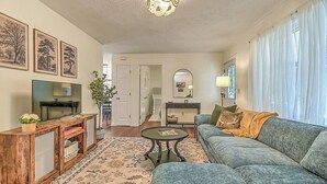 A living room with a television, sofa, coffee table, and decorative items. - Charming 3-bedroom cottage  (Abingdon)