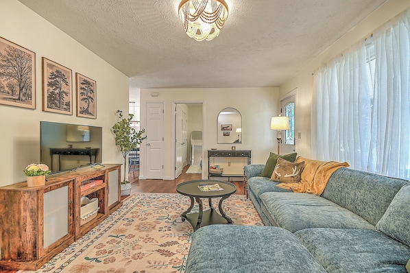A living room with a television, sofa, coffee table, and decorative items. - Charming 3-bedroom cottage  (Abingdon)