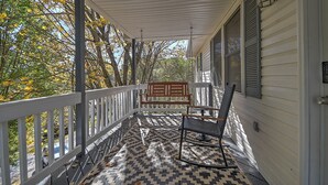 A covered porch with a patterned floor, a rocking chair, and a bench. - Charming 3-bedroom cottage  (Abingdon)