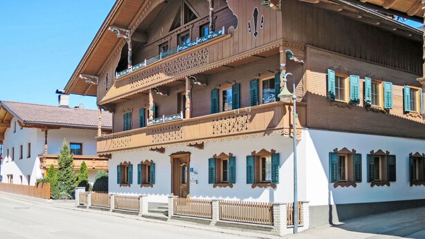 En traditionell byggnad i trä med balkonger, en balkong med en skylt och en utsikt över gatan.