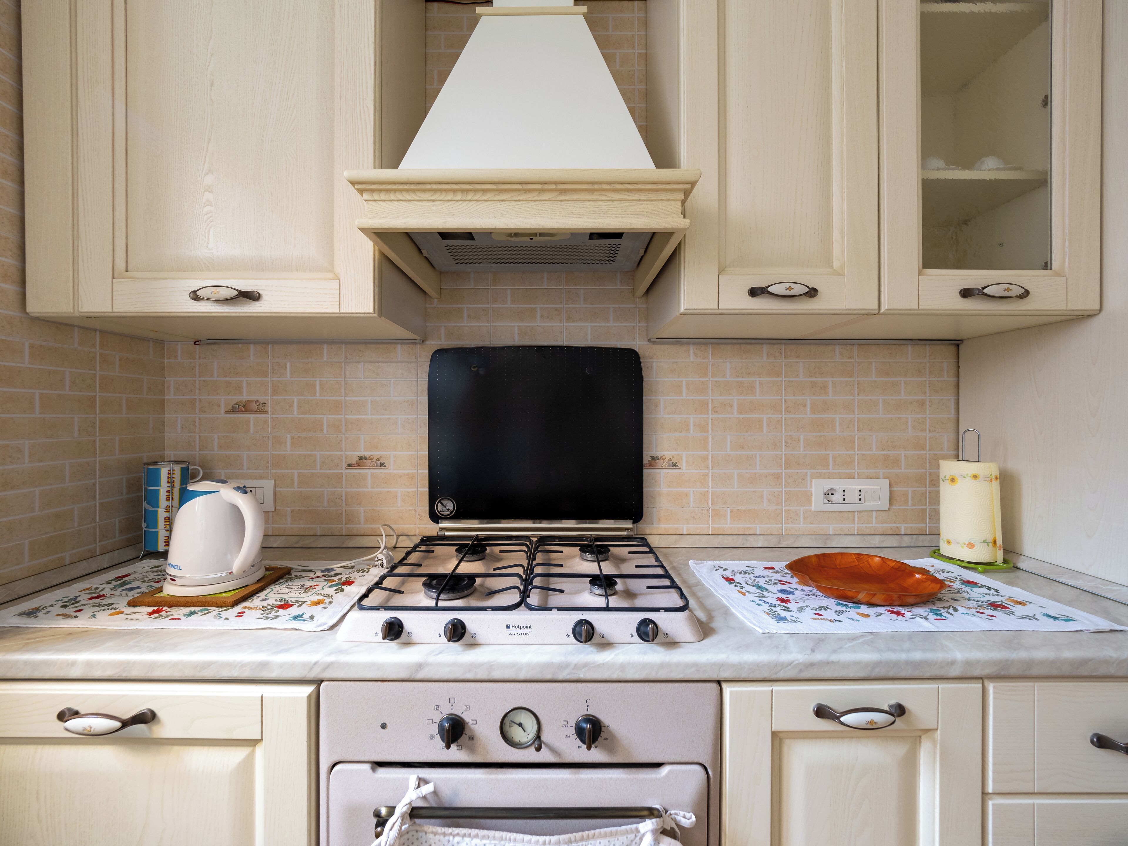 A kitchen with a gas stove, oven, and a range hood.