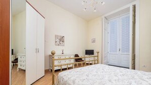 A bedroom with a bed, a dresser, a television, and a wardrobe. - Maya Home (Sorrento)