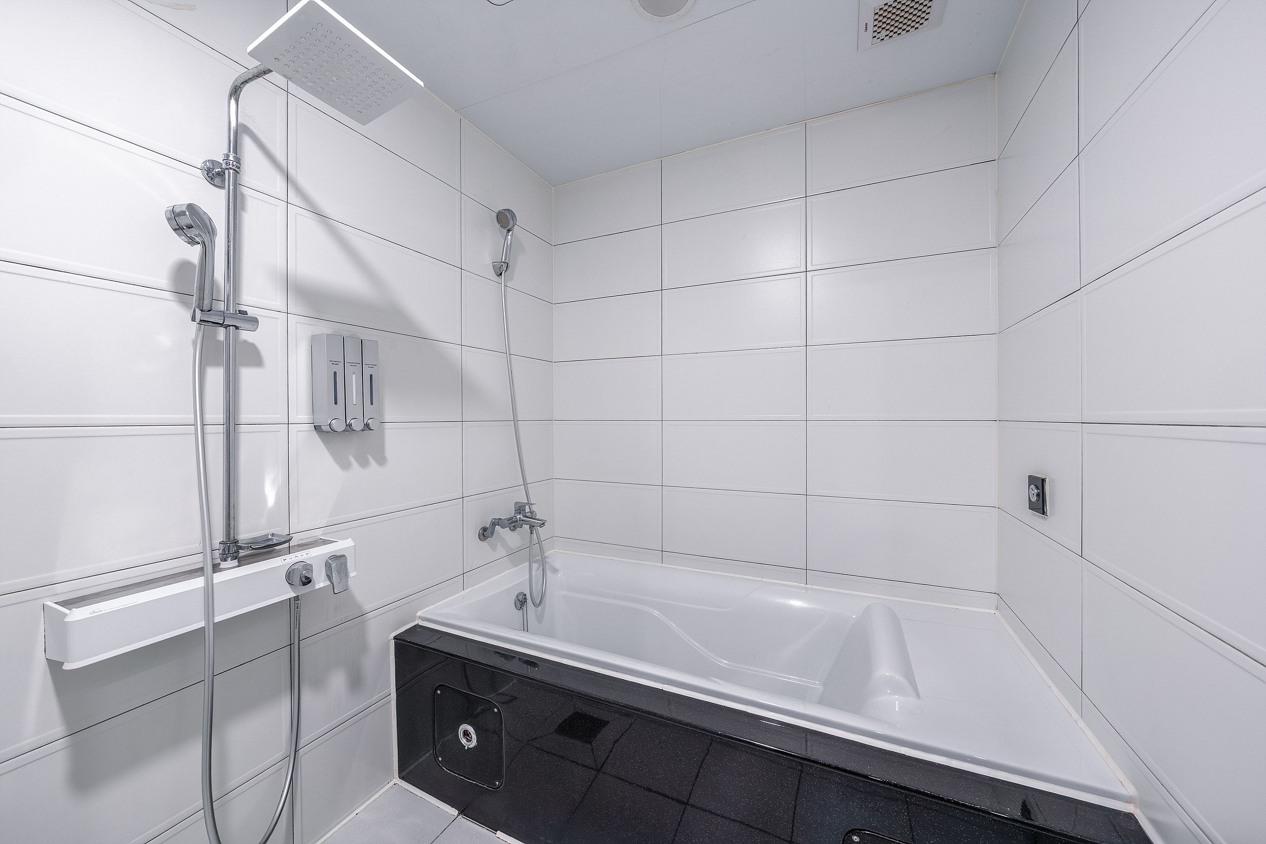 A modern bathroom with a bathtub, a shower area, and a toilet.