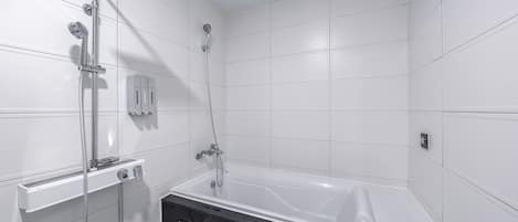 Un baño moderno con bañera, cabina de ducha y inodoro.